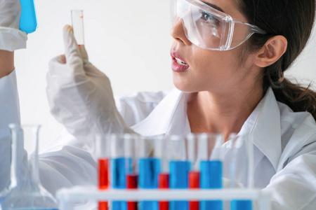 研究随笔女科学家在实验室工作,检查试管中的生物化学样品.